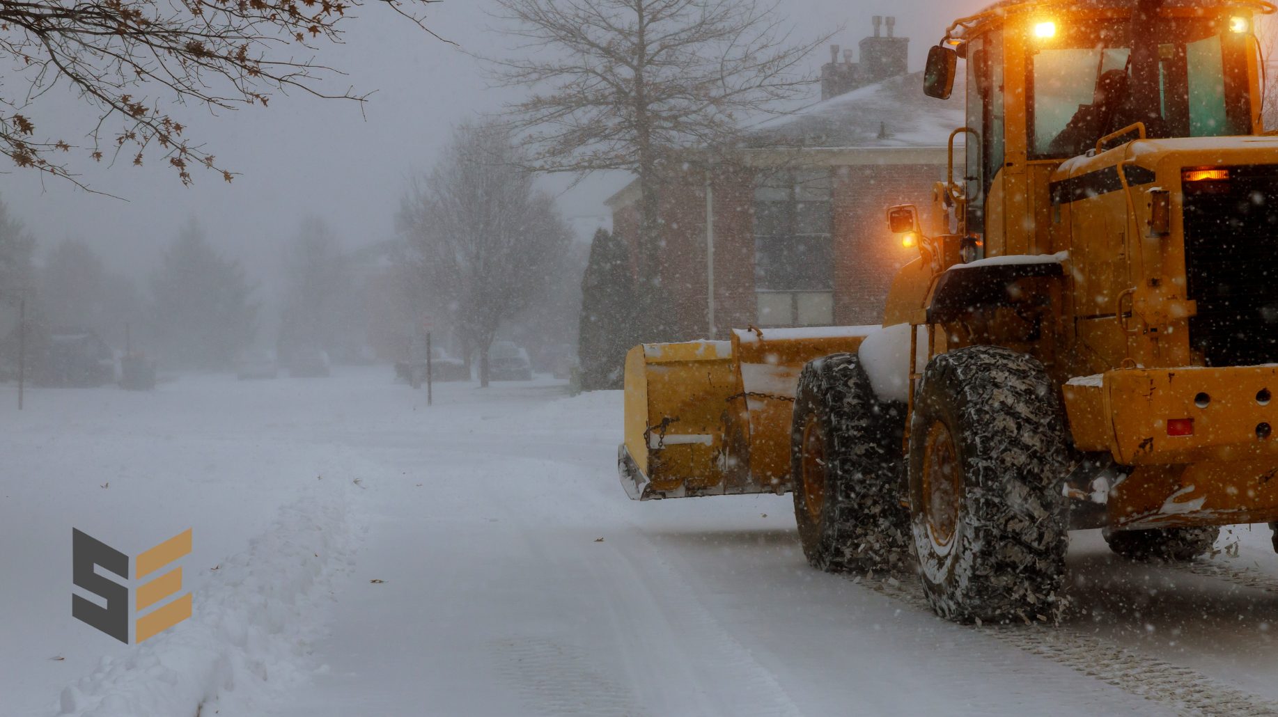 SilverEdge wheel loader clearing heavy snow with beacon lights on